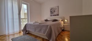 a bedroom with a bed and a window at Apartmani S&S in Stara Novalja