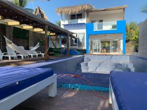 a resort with a hammock and a house at Casa Playa linda 28 in El Desengaño