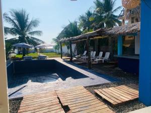 een zwembad naast een huis met palmbomen bij Casa Playa linda 28 in El Desengaño