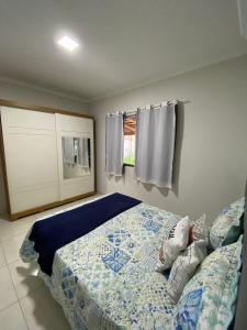 casa para alugar em Prado bahia. في برادو: غرفة نوم بسرير ولحاف ازرق وابيض