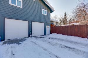 Deux portes blanches de garage sur une maison dans la neige dans l'établissement Cozy Apartment in Fairbanks about 2 Mi to Downtown!, à Fairbanks