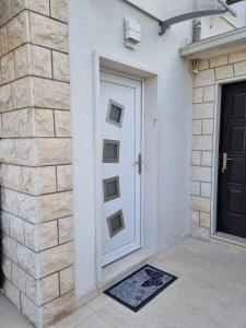 una puerta de una casa con una alfombra delante de ella en Apartments with a parking space Postira, Brac - 727, en Postira