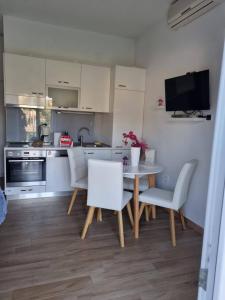 a kitchen with a table and chairs and a television at Apartments with parking space Postira, Brac - 727 in Postira
