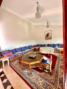 un soggiorno con divano e tavolo di ATGAL Ferme D'hote ad Azrou
