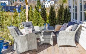 a patio with wicker chairs and a table on a deck at Nice Home In Halden With Kitchen in Halden