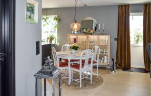 ein Esszimmer mit einem weißen Tisch und Stühlen in der Unterkunft Nice Home In Halden With Kitchen in Halden