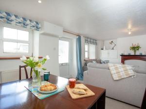 a living room with a table with a vase of flowers at Summer Cottage in Bideford