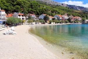 plaża z leżakami i domów nad wodą w obiekcie Rooms by the sea Krilo Jesenice, Omis - 17901 w mieście Jesenice