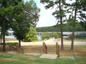 eine Holzbank in einem Park mit Seeblick in der Unterkunft Mountain Harbor King Guest Room on Lake Ouachita in Mount Ida