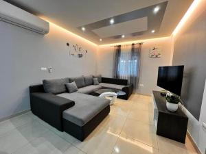uma sala de estar com um sofá e uma televisão de ecrã plano em Apartments with a parking space Kastel Novi, Kastela - 21085 em Kaštela