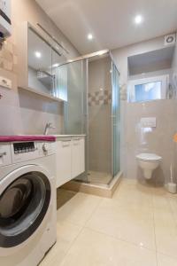 uma casa de banho com uma máquina de lavar roupa e um WC em Apartments with a parking space Kastel Novi, Kastela - 21085 em Kaštela