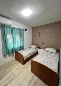 duas camas num quarto com cortinas verdes em Apartments with a parking space Kastel Novi, Kastela - 21085 em Kaštela