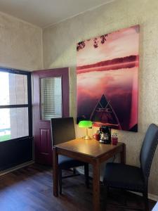 ein Zimmer mit einem Tisch und Stühlen sowie einem Gemälde an der Wand in der Unterkunft Mountain Harbor King Guest Room on Lake Ouachita in Mount Ida