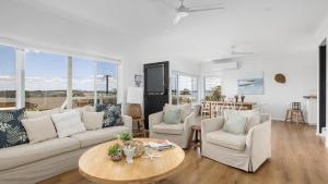 a living room with a couch and chairs and a table at Soul Bliss at Shoal Bay in Shoal Bay