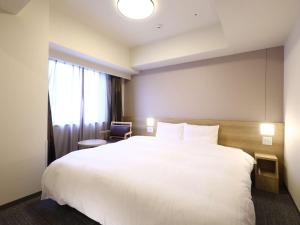 Ένα ή περισσότερα κρεβάτια σε δωμάτιο στο Dormy Inn Hiroshima Annex