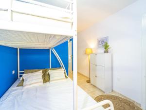 a bedroom with a bunk bed and a blue accent wall at EDEN RENTALS Caletillas Ocean Views in Candelaria