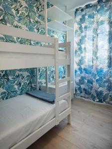 1 dormitorio con literas y papel pintado azul y blanco en La Dimora del Pescatore, en Vasto