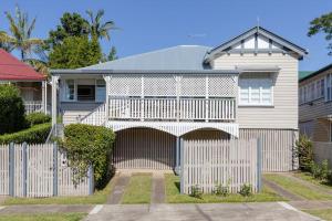 a white fence in front of a house at Quaint & Cosy 1 Bedroom Apartment in Queenslander. in Brisbane