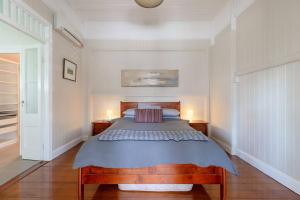 a bedroom with a large bed with two lamps at Quaint & Cosy 1 Bedroom Apartment in Queenslander. in Brisbane