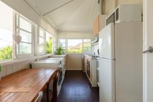 a kitchen with a refrigerator and a wooden table at Quaint & Cosy 1 Bedroom Apartment in Queenslander. in Brisbane