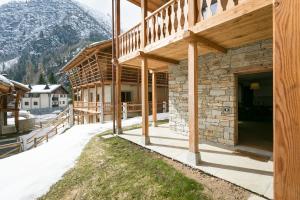 a building with a balcony with a mountain in the background at Mirtillo Blu Family Apartment in Alagna Valsesia