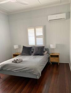 a bedroom with a large bed with two night stands at Charming 1920's 4Br freestanding Plantation Qldr. in Brisbane
