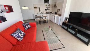 uma sala de estar com um sofá vermelho e uma televisão em Oasis house em Nazaret