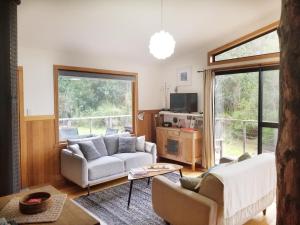 Southern Forest Accommodation في Southport: غرفة معيشة مع أريكة وطاولة