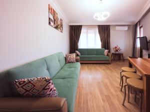 ein Wohnzimmer mit einem grünen Sofa und einem Tisch in der Unterkunft YILDIRIM LIFE APART in Istanbul
