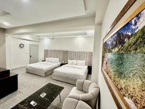 ein Hotelzimmer mit 2 Betten und einem Sofa in der Unterkunft MUDAN hotel and suite in Islamabad