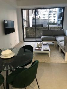 ein Wohnzimmer mit einem Glastisch und einer Couch in der Unterkunft New Spacious 1 Bedroom Apartment Rosebery in Sydney + 5 Fotos