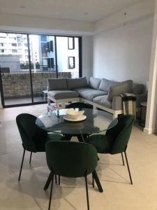 ein Wohnzimmer mit Tisch und Stühlen und einer Couch in der Unterkunft New Spacious 1 Bedroom Apartment Rosebery in Sydney