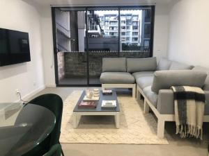 ein Wohnzimmer mit einer Couch und einem Couchtisch in der Unterkunft New Spacious 1 Bedroom Apartment Rosebery in Sydney
