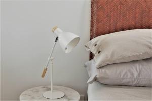 eine weiße Lampe auf einem Tisch neben einem Bett in der Unterkunft New Spacious 1 Bedroom Apartment Rosebery in Sydney