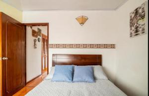 Un dormitorio con una cama con almohadas azules. en Excelente ubicación, movistar, parque simon Bolivar en Bogotá
