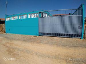 a blue gate on the side of a dirt road at Chácara Oliveira in Socorro