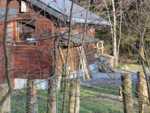 Ein rotes Haus mit einem Zaun daneben. in der Unterkunft Rustic Chalet ultimate relaxation in the forest in Sourbrodt