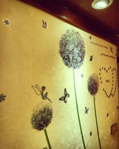 Una pared con tres dientes de león y mariposas. en Shinge Hotel en Hualien