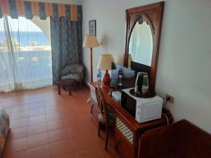 a room with a desk with a microwave and a mirror at Domina coral bay Sultan - private room in Sharm El Sheikh