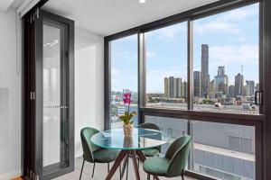 a dining room with a glass table and green chairs at Prime position 1.5 BR w/ view/ parking / roof pool in Brisbane