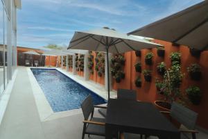 a table with an umbrella next to a swimming pool at Culiacan Marriott Hotel in Culiacán