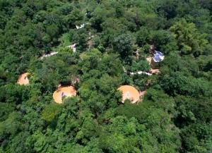 een bovenaanzicht van een groep tenten in de bomen bij Cabañas Camino Mágico in San Miguel del Puerto