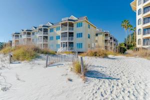 a row of apartment buildings on a beach with sand at Port O' Call G304 - Modern Oceanview! Atlantic Escape! in Isle of Palms