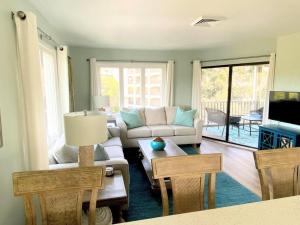 a living room with a couch and a table at Port O' Call G304 - Modern Oceanview! Atlantic Escape! in Isle of Palms