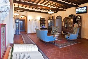 ein Wohnzimmer mit blauen Stühlen und einer Uhr in der Unterkunft Hotel Villa Cheli in Lucca