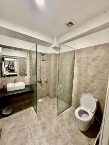 y baño con aseo, lavabo y ducha. en MUDAN hotel and suite, en Islamabad