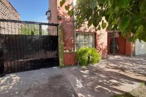 una puerta a un edificio de ladrillo con una valla en Departamento muy amplio y cómodo. Impecable! PB en San Rafael