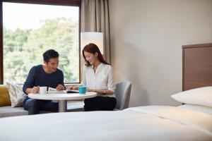 Un uomo e una donna seduti a un tavolo in una stanza d'albergo di Karuizawa Marriott Hotel a Karuizawa