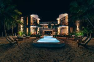 a swimming pool in front of a resort at night at Cucu Hotel El Cuyo in El Cuyo