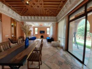 una gran sala de estar con mesa de madera y sillas. en Villa Dahlia, en Marrakech